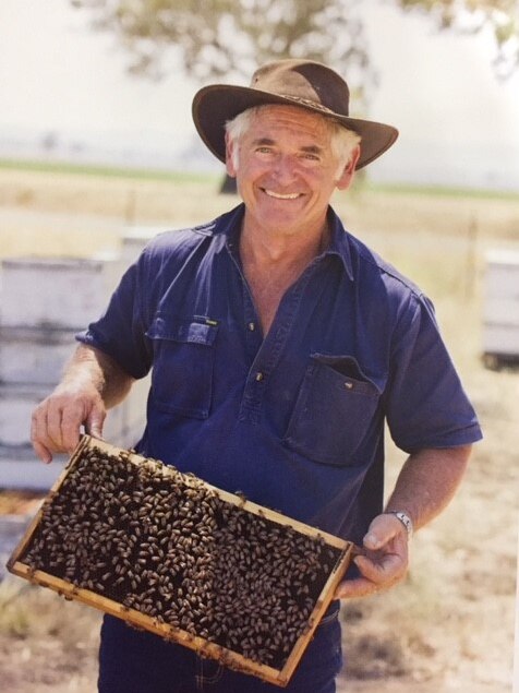 Rex Carruthers holds a hive frame.