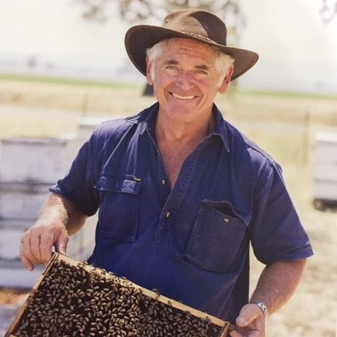 Rex Carruthers holds a hive frame.