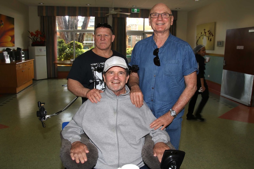 Mick McKay in a wheelchair flanked by Andrew Gormley and Gerry Carter.