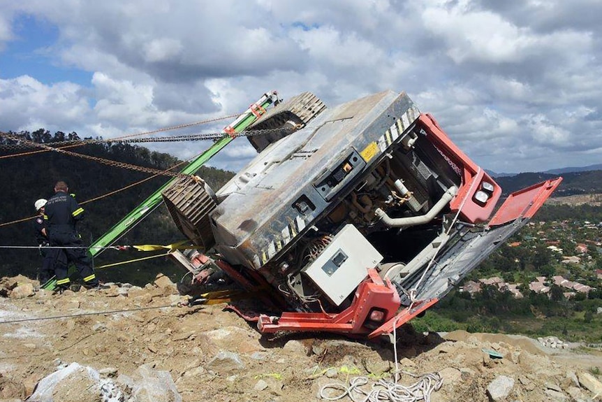 The excavator remained precariously perched atop a cliff edge in the quarry.