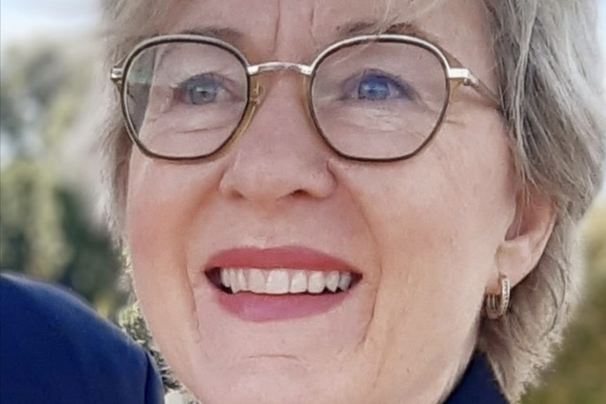 A woman wearing glasses smiling