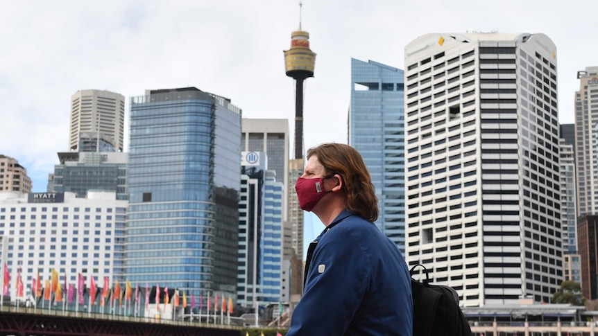 a woman wearng a red mask with the sydney centrepoint tower in the background