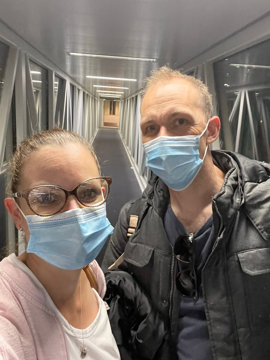 A selfie of a man and woman wearing masks about to board a plane