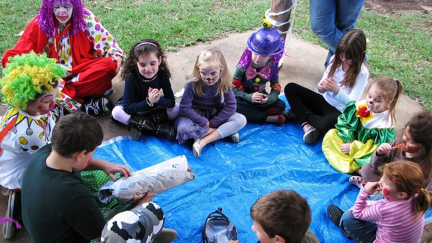 Children sitting in a circle playing pass the parcel