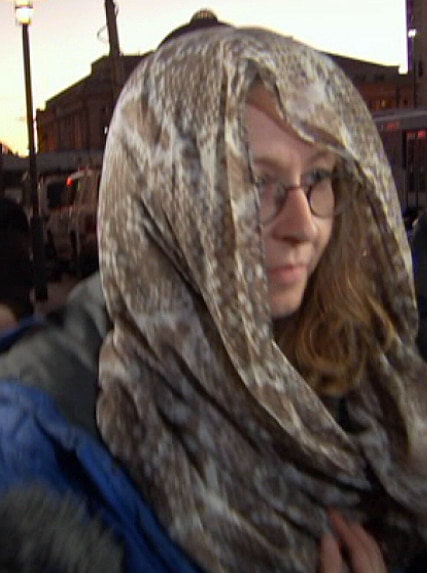 Lisa Barrett leaves Adelaide Magistrates Court with her head covered.