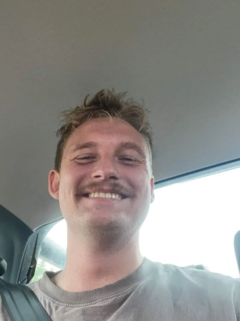 A man smiles in a car