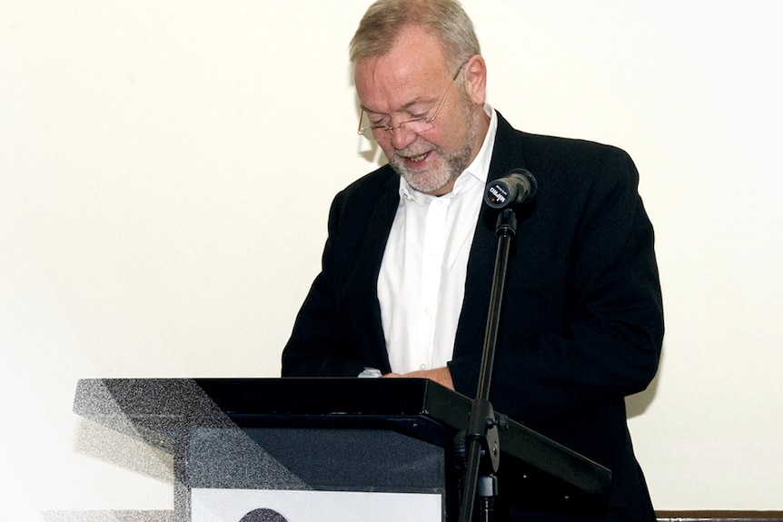 Former Metro North Health and Hospital Service chief executive Malcolm Stamp stands at a lectern.