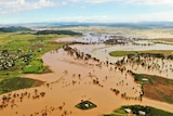 Brown floodwater spills out across plains.