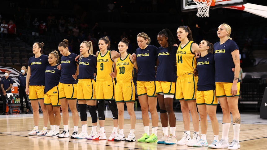 The Australian women's national basketball team stand arm in arm for the national anthem