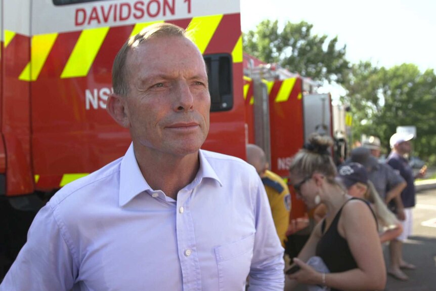 Tony Abbott standing in front of RFS fire engines