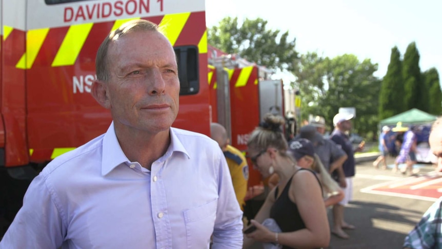 Tony Abbott standing in front of RFS fire engines