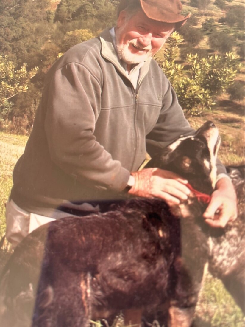 A man on his farm with his dog