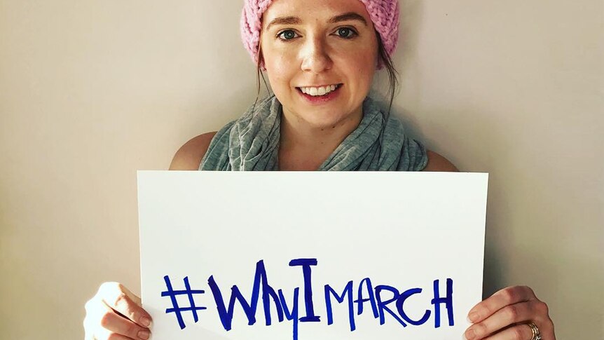 A woman holds a sign that says: '#WhyIMarch'.
