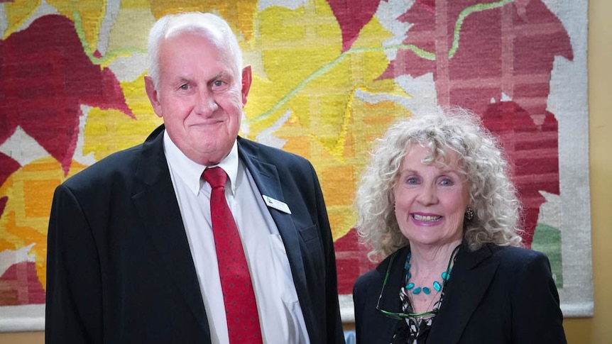 A man and woman standing together smiling