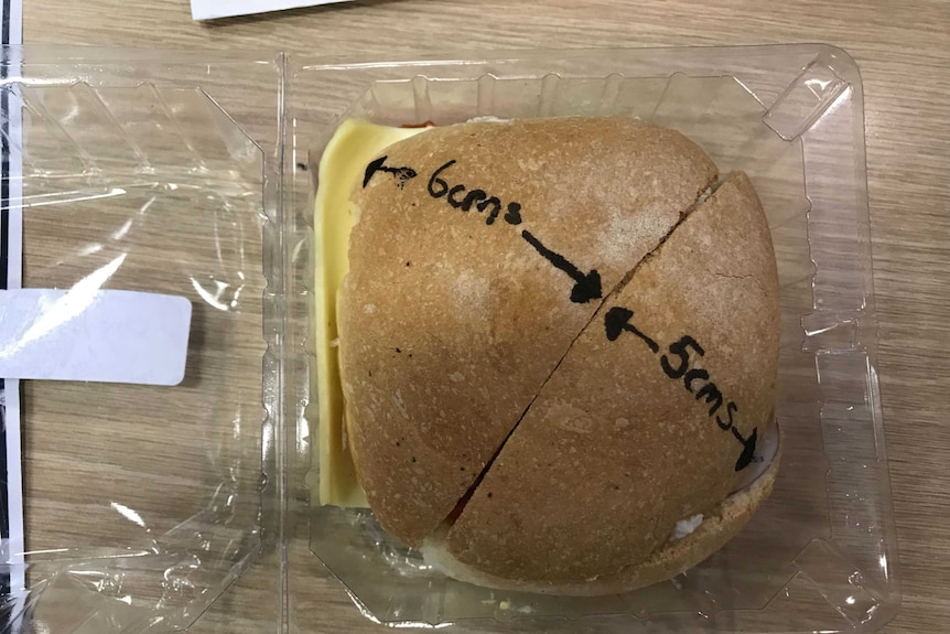 A bread roll cut diagonally with texta outlining the dimensions of each 'half'