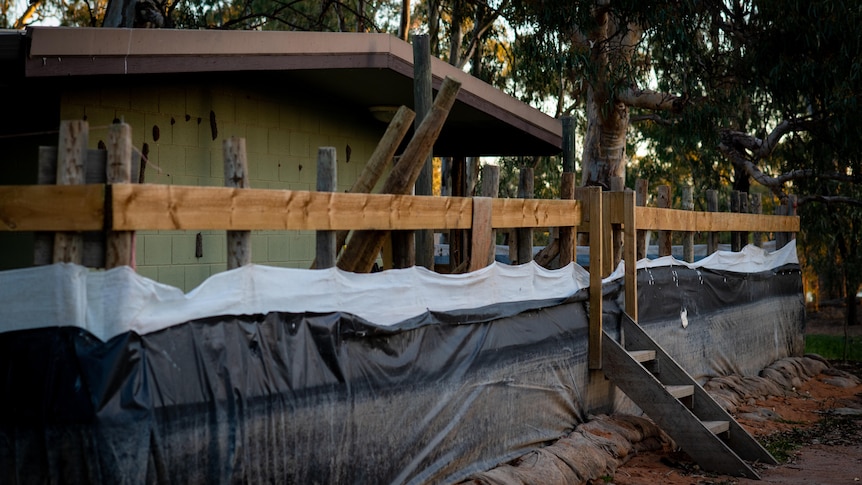 A house with a fence around it lined with black and white cloth