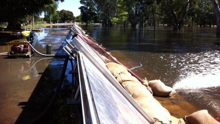 Water is pumped from one side of the levee back into the floodwaters at Nathalia.