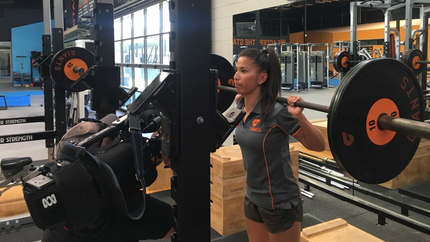 GWS AFL women's player Mai Nguyen lifting weights.