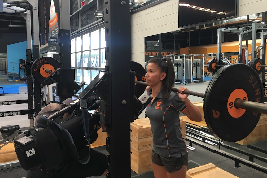 GWS AFL women's player Mai Nguyen lifting weights.