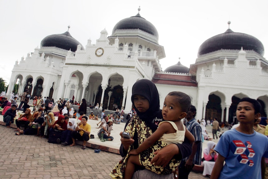 People gather outside Baiturrahman Mosque after an earthquake hit Banda Aceh