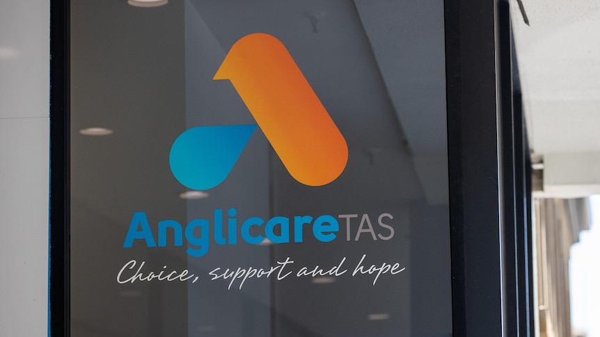 Anglicare Tasmania logo on a window.