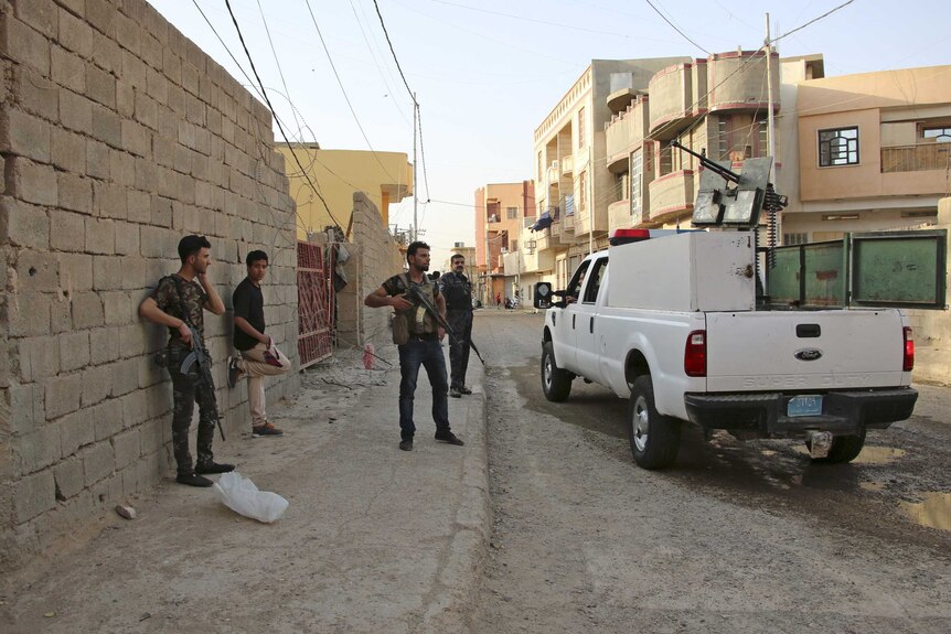 Fighters and police stand guard in Ramadi