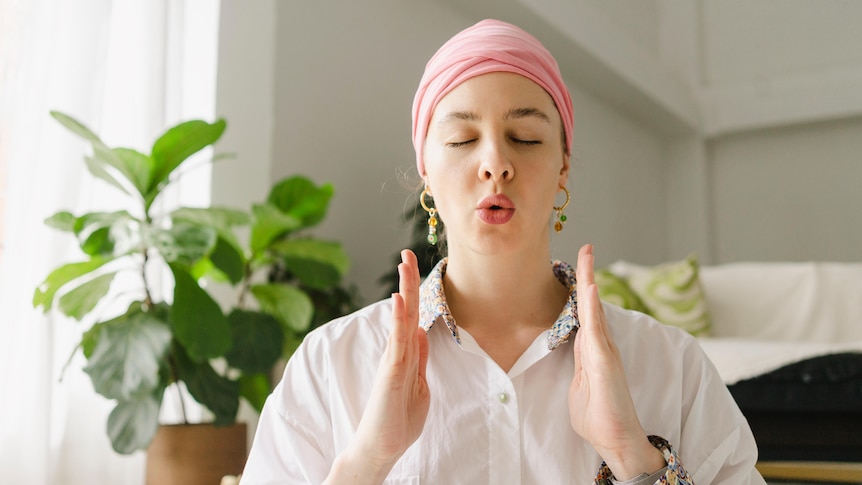 woman breathing and wearing a pink scarf and hoop earrings