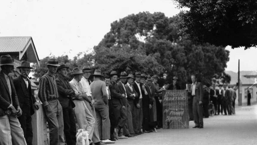 A black and white photo of a line of unemployed male relief workers.