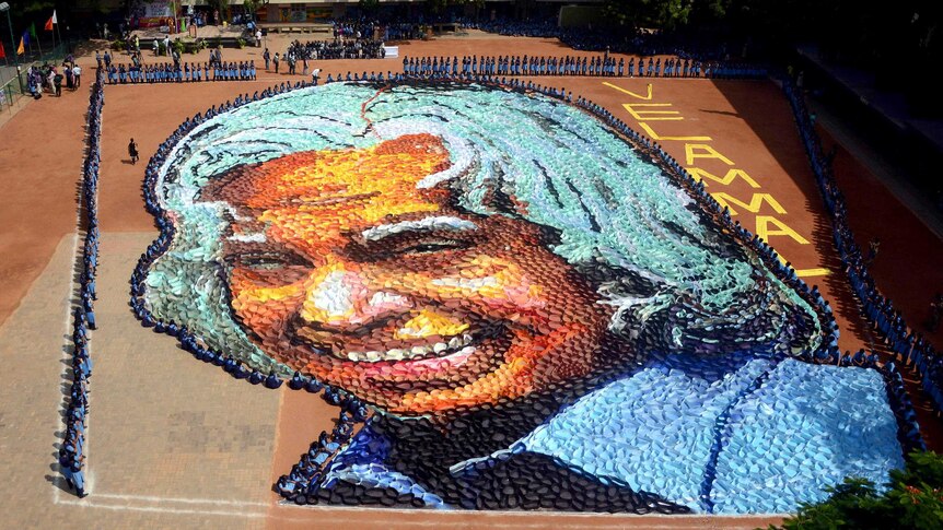 Students gather around a 1,400 square metre portrait, made from coloured paper, of the late former Indian president APJ Kalam.