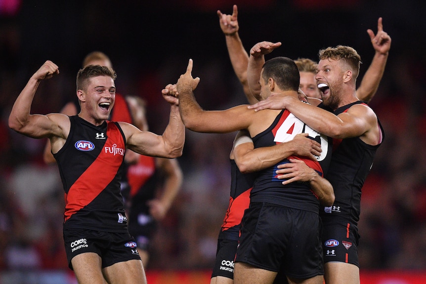 Essendon players react to a goal by Alec Waterman