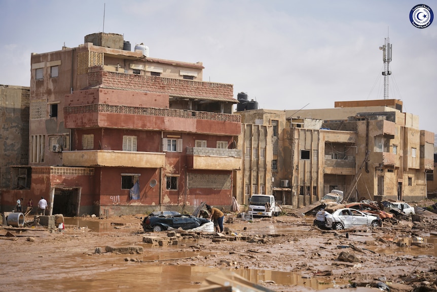 Cars and rubble sit in a street in Derna, Libya.