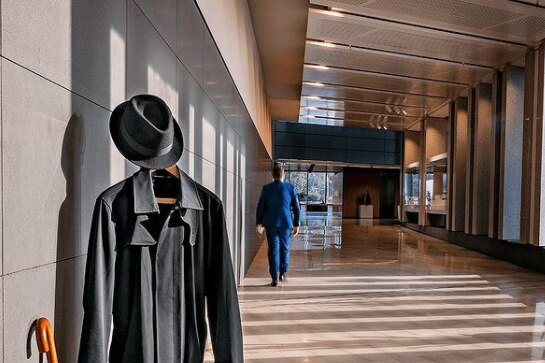 An Instagram post shows a trenchcoat on a hanger and someone walking away in normal clothes.