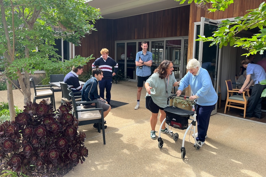 Students and aged care residents in a courtyard.