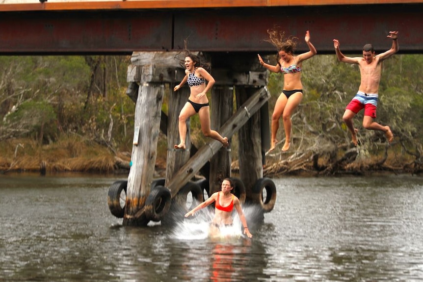 Jumping off the old railway bridge at the river mouth caravan park in Denmark WA