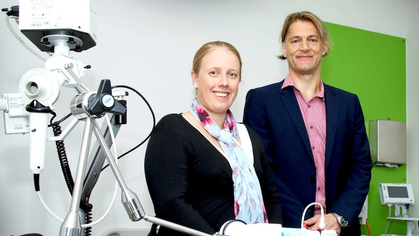 Dr Vanessa Murphy and Joerg Mattes stand side by side next to a piece of lab equipment