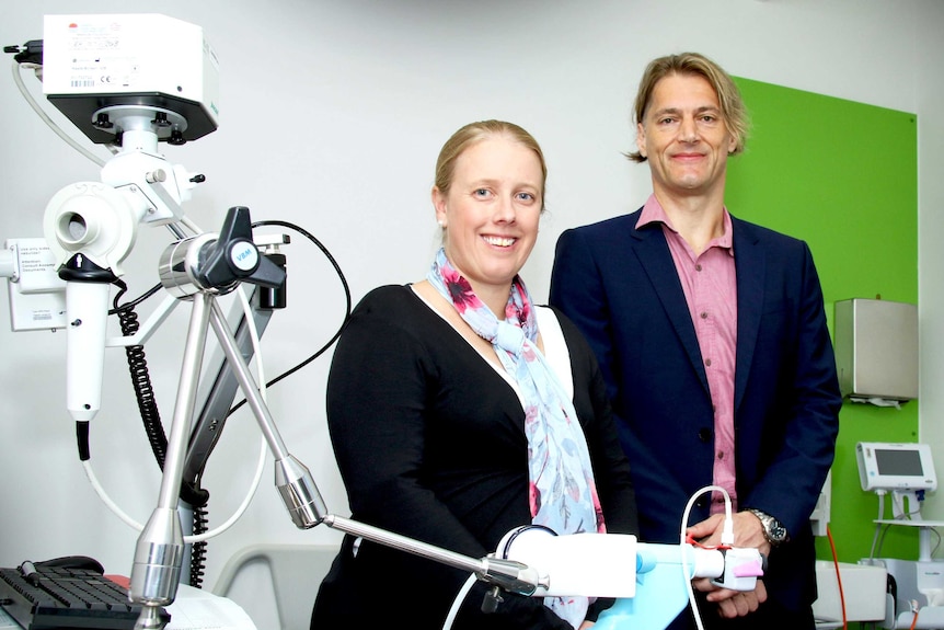 Dr Vanessa Murphy and Joerg Mattes stand side by side next to a piece of lab equipment
