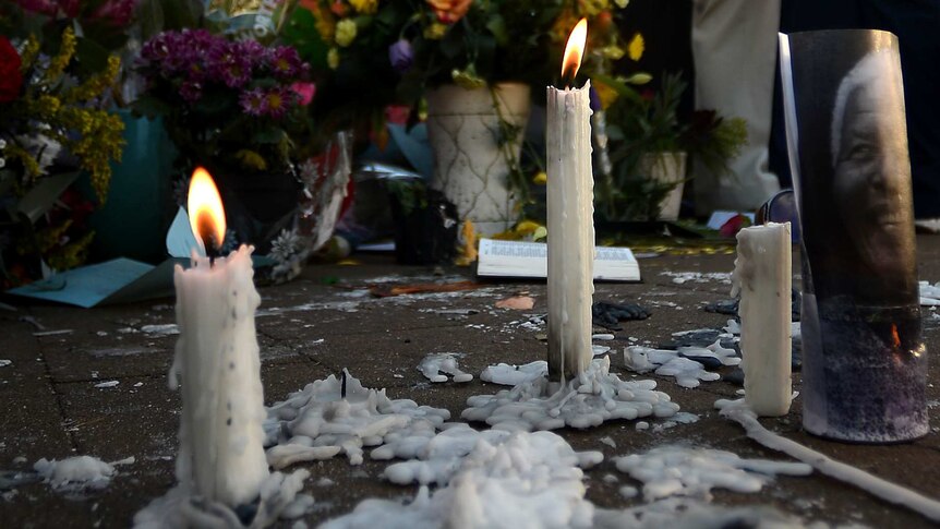 Candles burn outside the Pretoria hospital where Nelson Mandela remains in critical condition