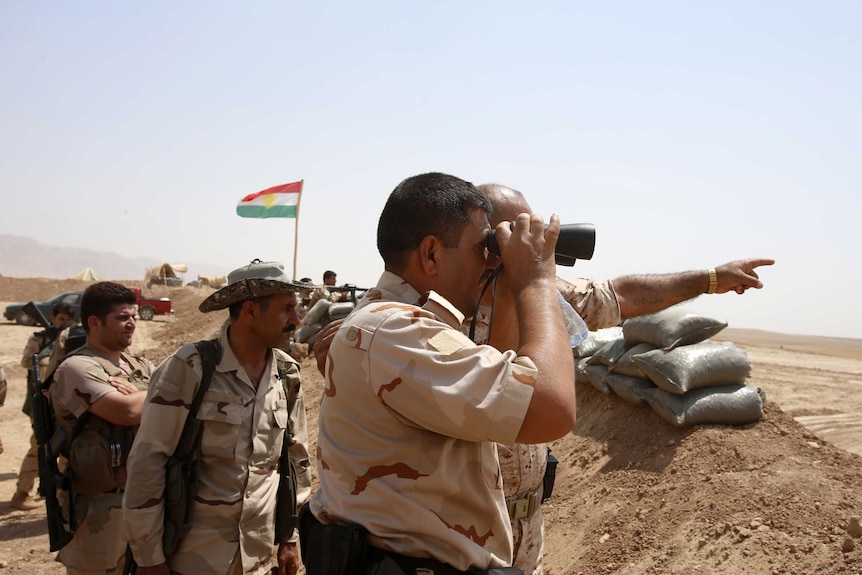35 years later... Kurdish Peshmerga fighters stand guard after the withdrawal of IS insurgents.