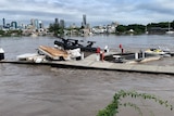 A jetty surrounded by debris in the Brisbane river.