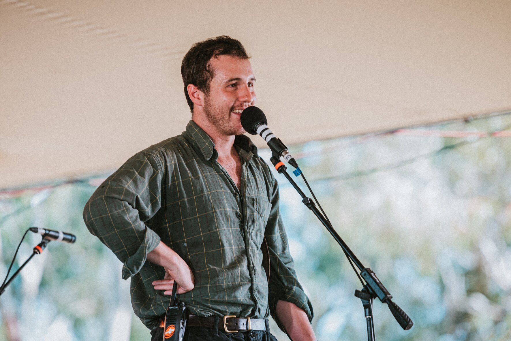 Sam Pyers speaks into a microphone on a stage.