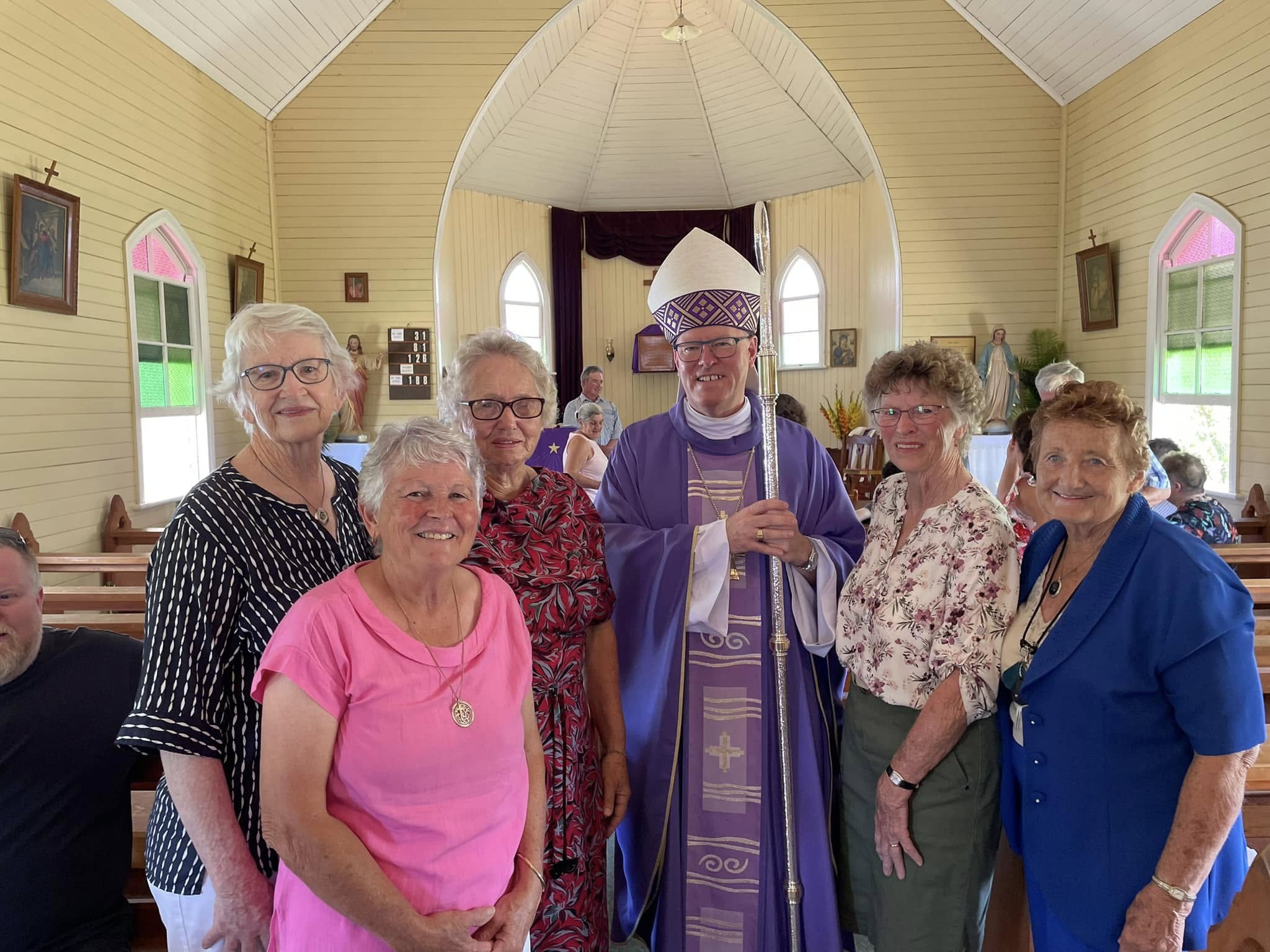 Группа людей, стоящих внутри церкви.