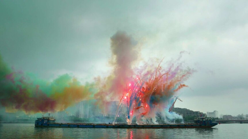 Colourful smoke display against cloudy sky.