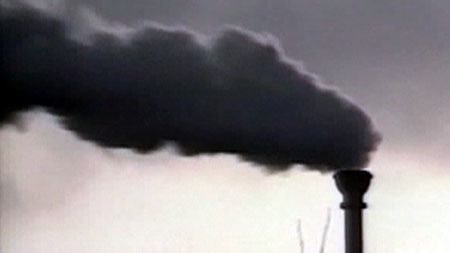 A smokestack pumps out smoke into the air.