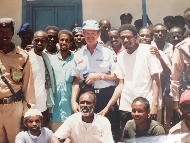 A crowd of Somalia posed for a photo with William Kirk in the centre