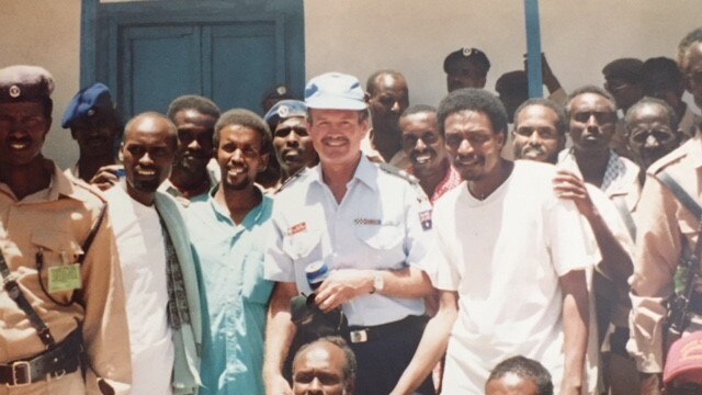 A crowd of Somalia posed for a photo with William Kirk in the centre
