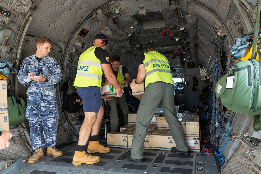 People loading boxes onto an aircraft. 