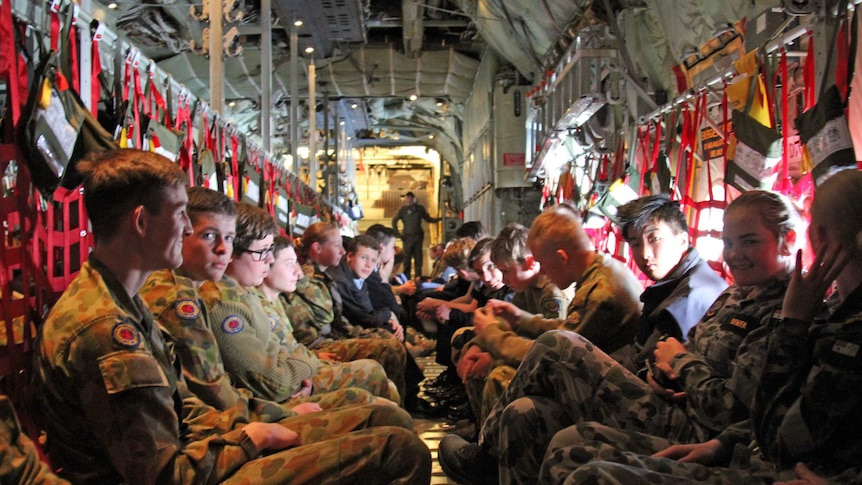 Young armed forces cadets sitting on a C-130J Hercules aircraft