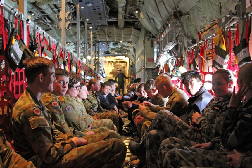 Young armed forces cadets sitting on a C-130J Hercules aircraft