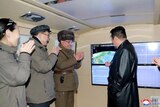 Military members applaude nation's leader in North Korea.