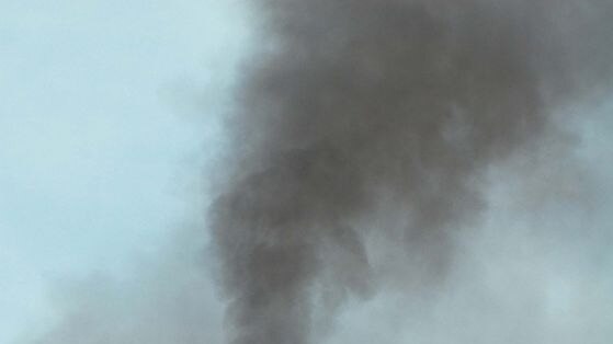 An industrial chimney emits smoke